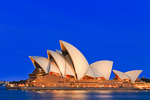 Sydney, Australia - November 15, 2016: Iconic worlds' buildings - Sydney Opera house in full glory at sunset, brightly illuminated.