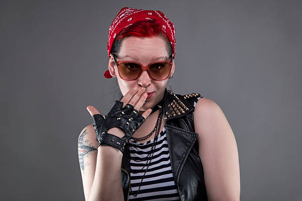 Posing shy punk woman in sunglasses Posing shy punk woman in sunglasses on gray background black pin up girl tattoos stock pictures, royalty-free photos & images