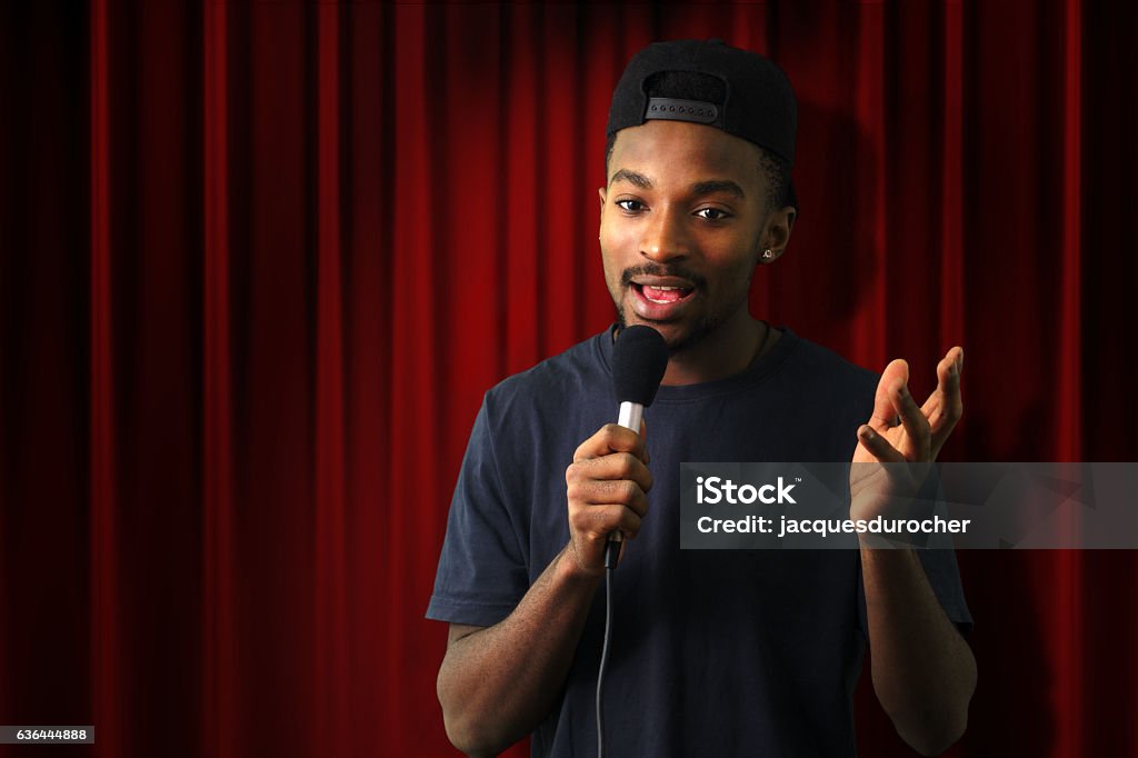 young singer vocalist on stage live show red curtain young man in concert red theater comedy vocalist singer microphone Comedian Stock Photo