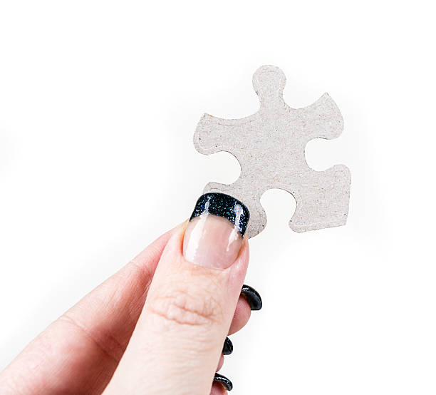istock Manicured hands holding puzzle pieces isolated on white background 636446962