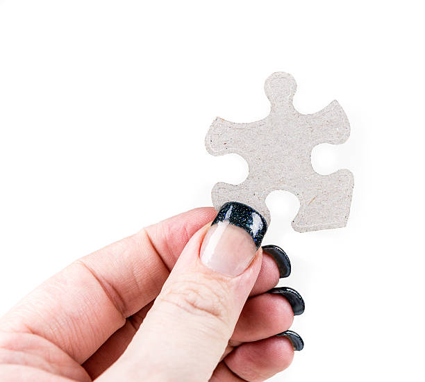 istock Manicured hands holding puzzle pieces isolated on white background 636446968