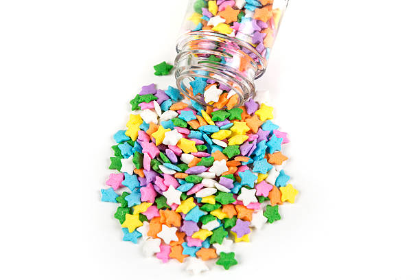 istock Assorted rainbow colored sprinkles and bottle isolated on white background 636447966