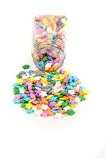 istock Assorted rainbow colored sprinkles and bottle isolated on white background 636447982