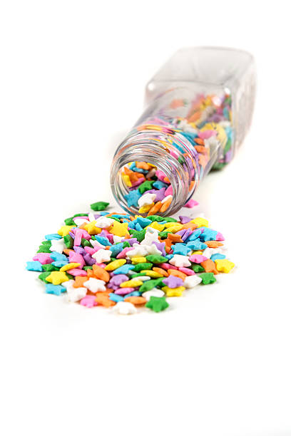 istock Assorted rainbow colored sprinkles and bottle isolated on white background 636447988