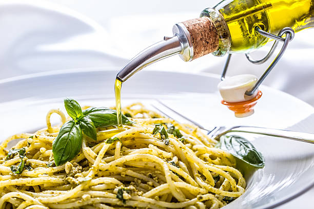 spaghetti con salsa di pesto fatta in casa olio d'oliva e foglie di basilico - parmesan cheese pasta italian culture food foto e immagini stock