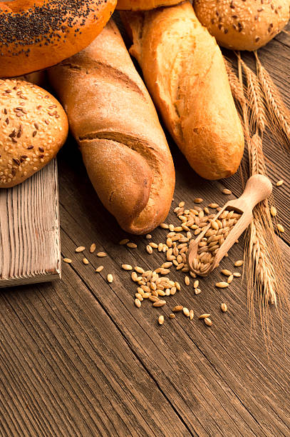istock Spoon with grain, bread and buns on the wooden desk 636452144