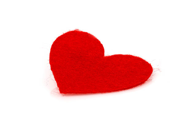 red heart Hand Made red heart made of felt inclined on a white background felt heart shape small red stock pictures, royalty-free photos & images