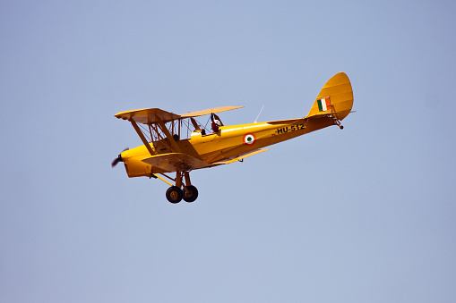 Bengaluru, Karnataka, India - February 20, 2015: The de Havilland DH.82 Tiger Moth is a 1930s biplane designed by Geoffrey de Havilland and was operated by the Royal Air Force (RAF), Indian Air Force (IAF) and others as a primary trainer. It participated in Aero India after a complete restoration by Indian Air Force to preserve the heritage. Many other nations used the Tiger Moth in both military and civil applications, and it remains in widespread use as a recreational aircraft in many countries.