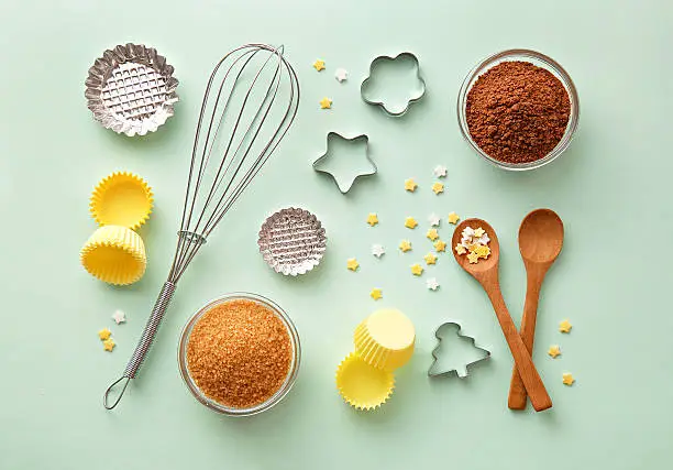 Photo of Dessert ingredients and utensils on green pastel background. Top view