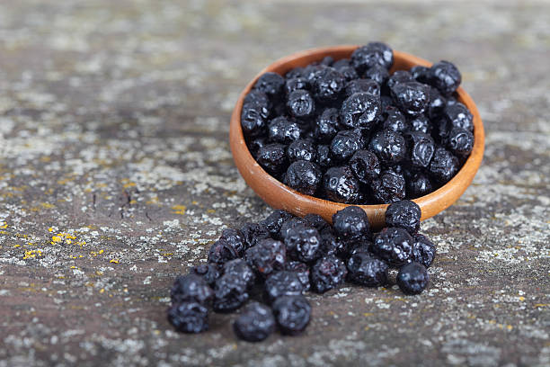 dried blueberries fruit in wooden bowl - meteo imagens e fotografias de stock