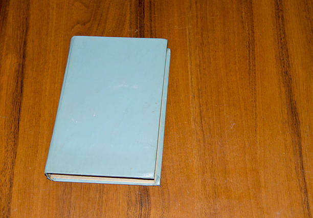 istock Old book on wooden table 636459564