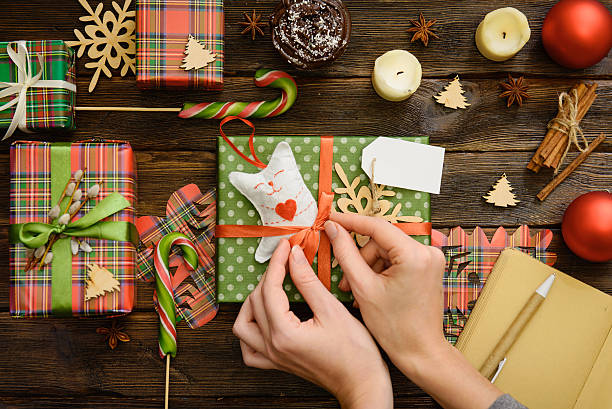 istock Woman's hands wrap christmas handmade present in paper 636461198