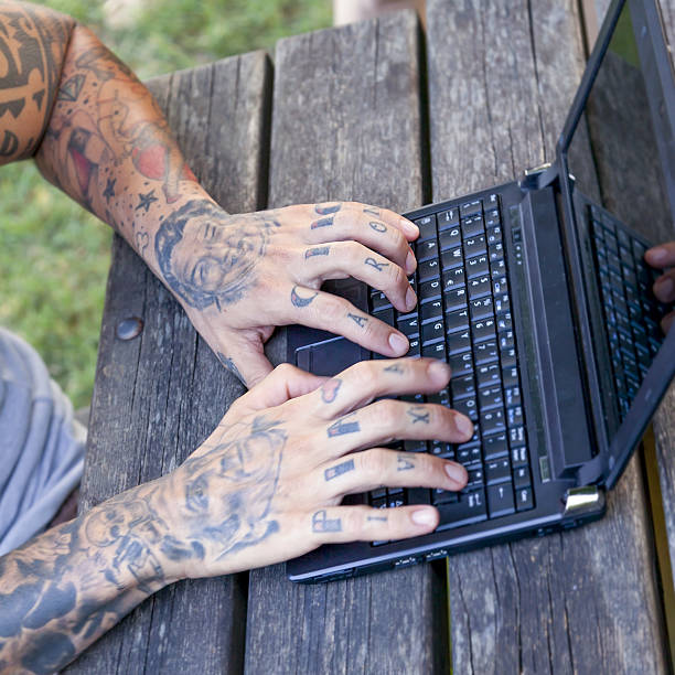 istock hands of a tattooted man working with computer outdoor 636464166