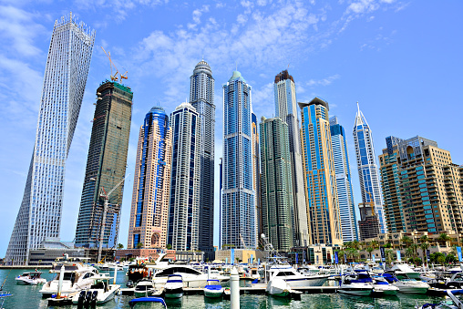 UAE, Dubai - March 27, 2015: Dubai marina, apartment buildings surrounding the marina, some are as tall as the Eiffel tower. Port with expensive boats close up.