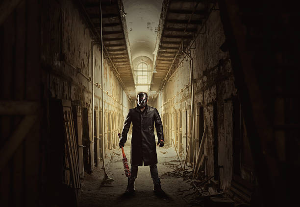 istock Killer with bloody bat in abandoned building. 636465350