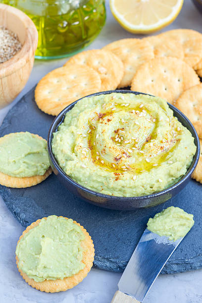 zdrowy hummus z awokado, podawany z krakersami, pionowy - avocado lemon snack cracker zdjęcia i obrazy z banku zdjęć