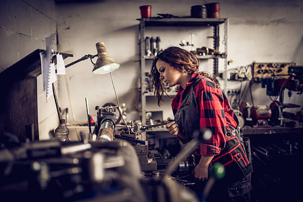 Young woman mechanic Young cute woman mechanic working alone in her workshop. toughness photos stock pictures, royalty-free photos & images