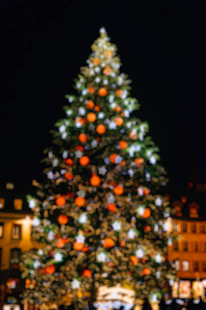 istock Defocused Christmas tree in central square city 636471660