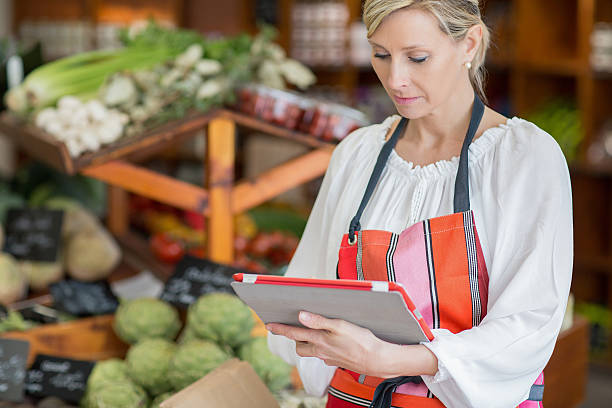 istock Woman Holding Digital Tablet In Grocery Store 636472640