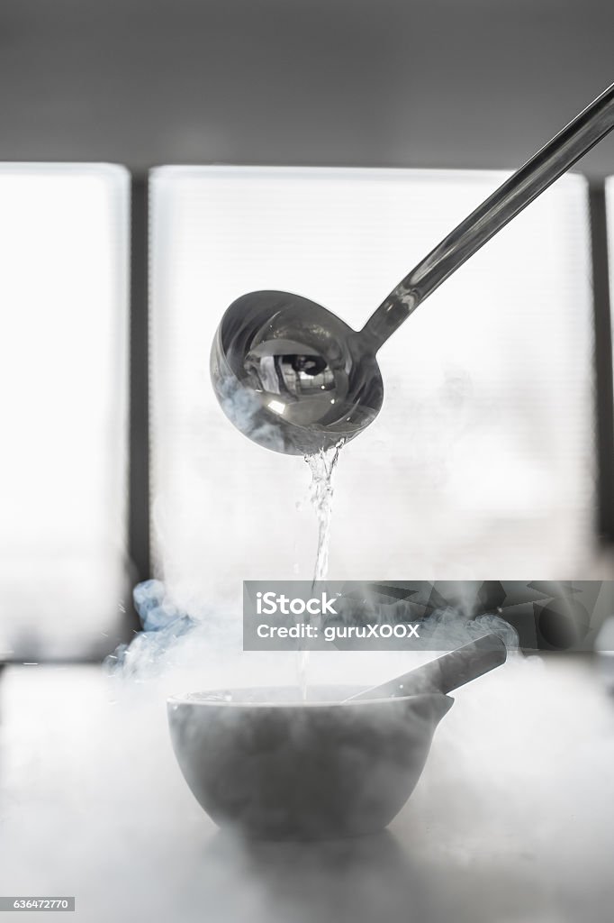 Laboratory experiment with liquid nitrogen in laboratory mortar Laboratory experiment with liquid nitrogen in laboratory mortar with pestle and ladle spoon Liquid Stock Photo