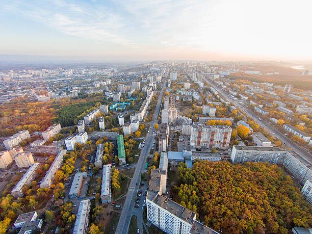 istock Autumn in city. Panoramic aerial view at road, forest, river. 636473080