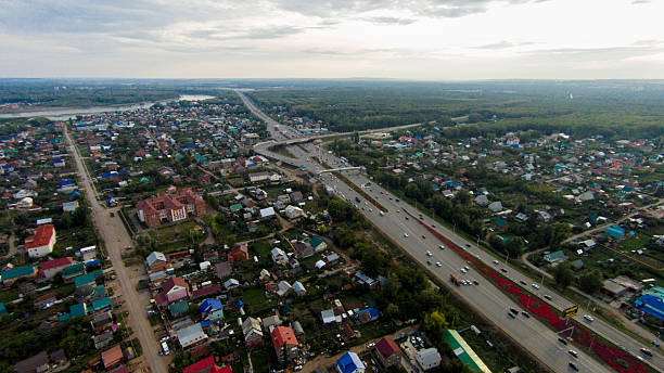 istock Autumn in city. Panoramic aerial view at road, forest, river. 636474980