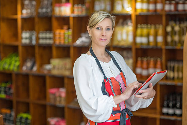istock Woman Holding Digital Tablet In Grocery Store 636475008