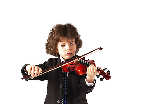 istock Little curly boy thoughtfully, playing a musical instrument. White background. 636477374
