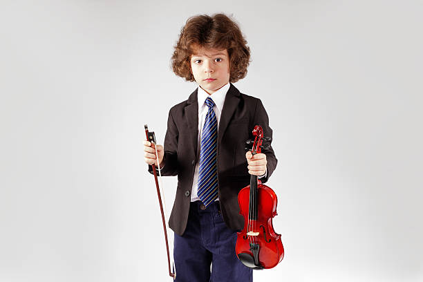 istock Handsome cute boy in a business suit holding a violin 636477666