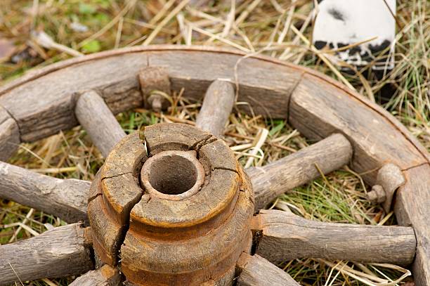 istock wooden wheel lying on the yellow grass 636478368