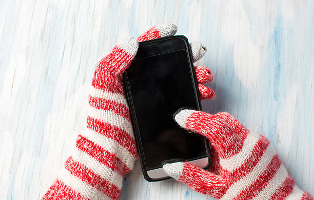 hands using phone in winter gloves - glove winter wool touching imagens e fotografias de stock