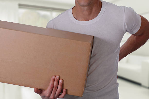 istock Man with back pain moving boxes at home interior 636486790