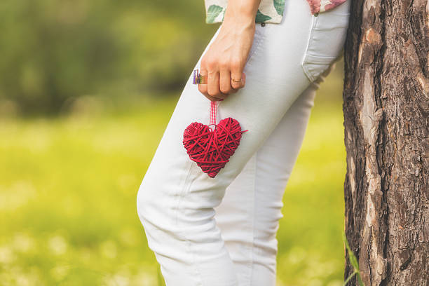 Girl making a heart outdoors.