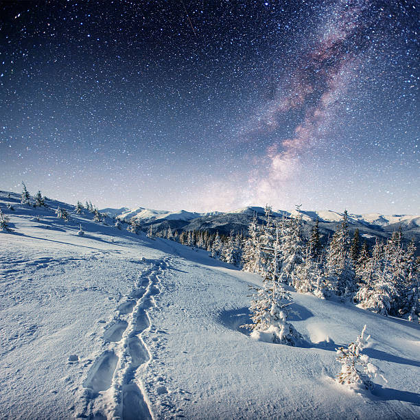 istock starry sky in winter snowy night. fantastic milky way 636498986