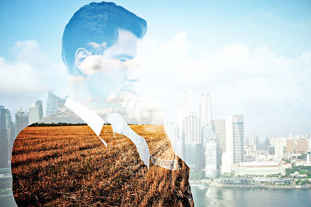 istock Man on field and city background 636499340