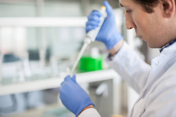 scientist in the laboratory filling test tubes with pipette - close up medical test exam people imagens e fotografias de stock