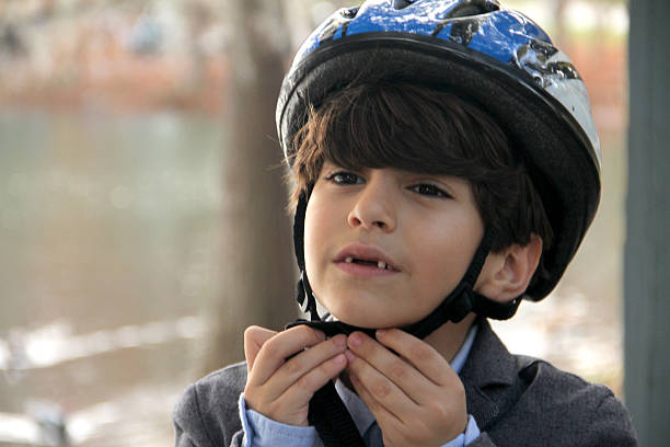 istock Smart boy opening helmet in a park cycling 636508628