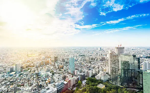 Business and culture concept - panoramic modern city skyline bird eye aerial view under dramatic sun and morning blue cloudy sky in Tokyo, Japan