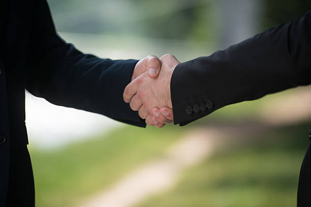 istock Businessman Shaking Hands Outside The Office 636510030