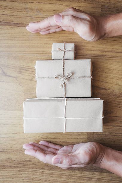 istock Hand with parcel gift box wrapped with hands carrying 636510500