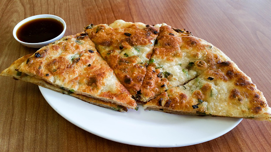 A scallion pancake is a Chinese savory, unleavened flatbread folded with oil and minced scallions. Unlike Western pancakes, it is made from dough instead of batter.