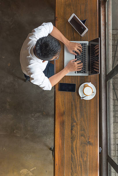 istock Businessman using laptop, smartphone and tablet at cafeteria 636519358