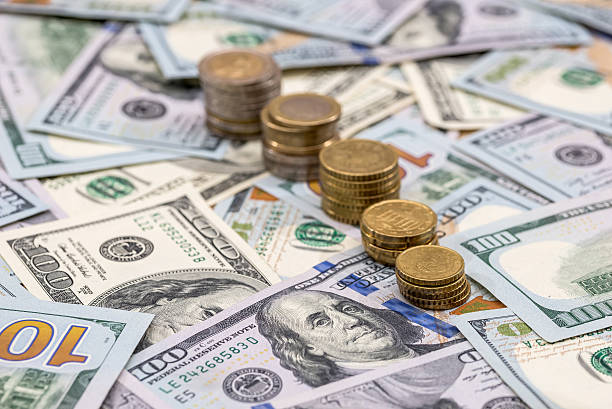 istock dollar bills and us coin as background. 636519386