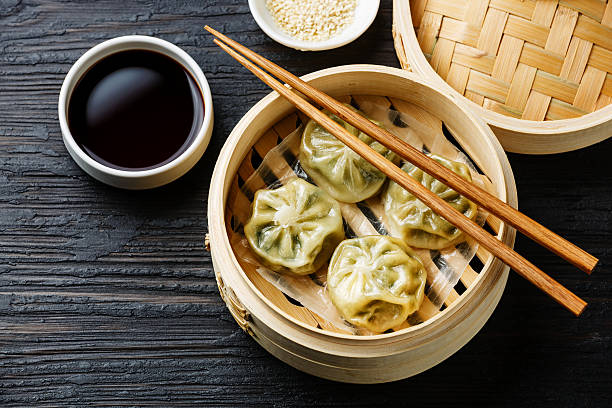 Steamed dumplings Dim Sum Steamed dumplings Dim Sum in bamboo steamer on black burned wooden background soy sauce photos stock pictures, royalty-free photos & images
