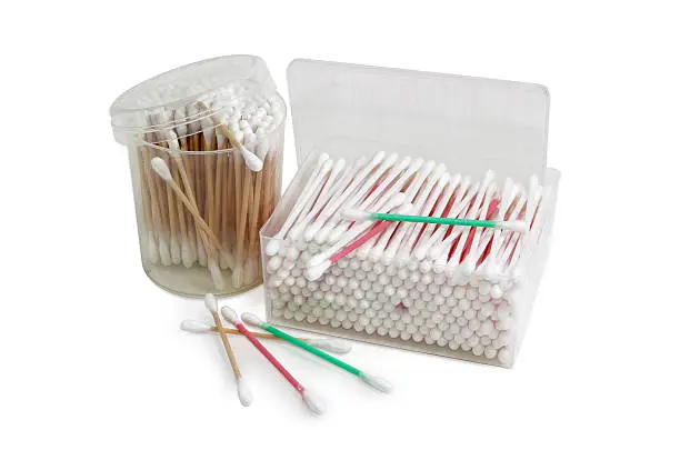 Cotton swabs on a white, red and green plastic rods in rectangular plastic container, cotton swabs on a wooden rods in round plastic container and several cotton buds separately on a light background