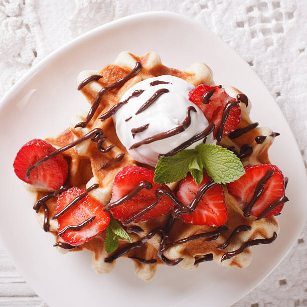 istock waffles with strawberries, whipped cream and chocolate closeup. 636523762
