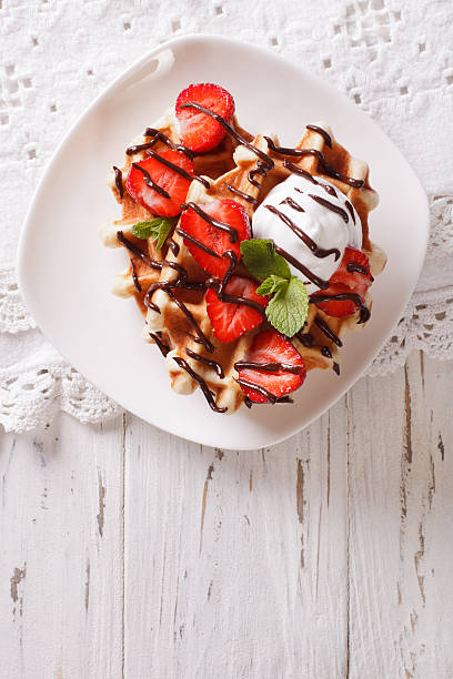 istock waffles with strawberries, whipped cream and chocolate closeup. 636524754