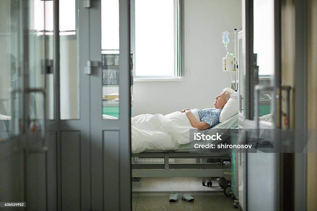 Sick and lonely Aged woman lying in emergency ward Hospital Stock Photo