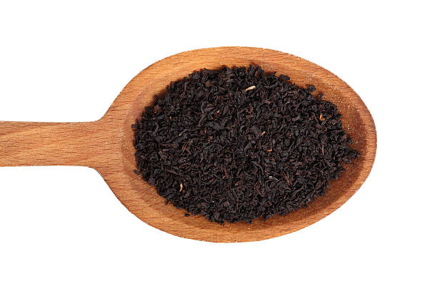 istock Loose dried black tea leaves on wooden spoon 636526498