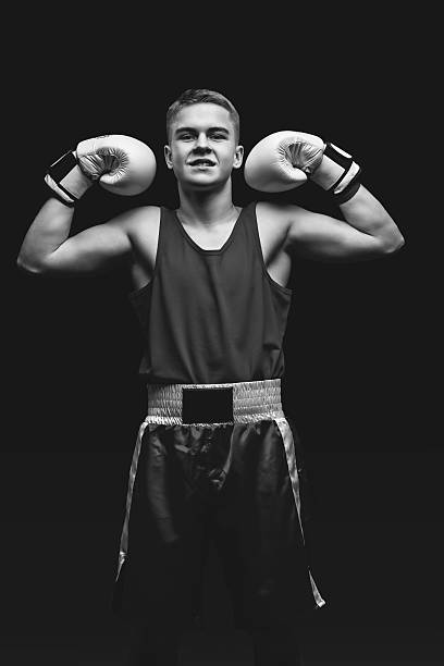 istock Young boxer sportsman on black background 636529832